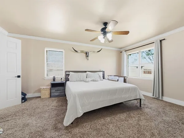 a bedroom with a large bed chandelier and a window