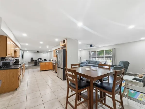 a dining hall with stainless steel appliances a dining table and chairs