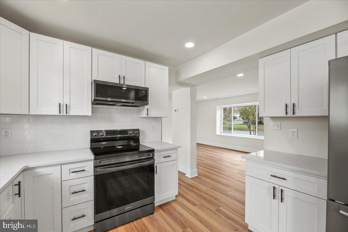 19 Intrepid Drive Sewell, NJ 08080 - Photo 13 of 47 a kitchen with granite countertop white cabinets and black appliances
