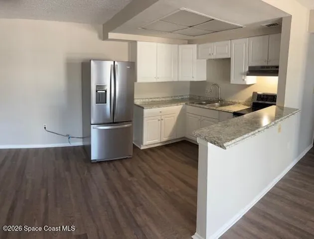 a kitchen with a refrigerator and a sink