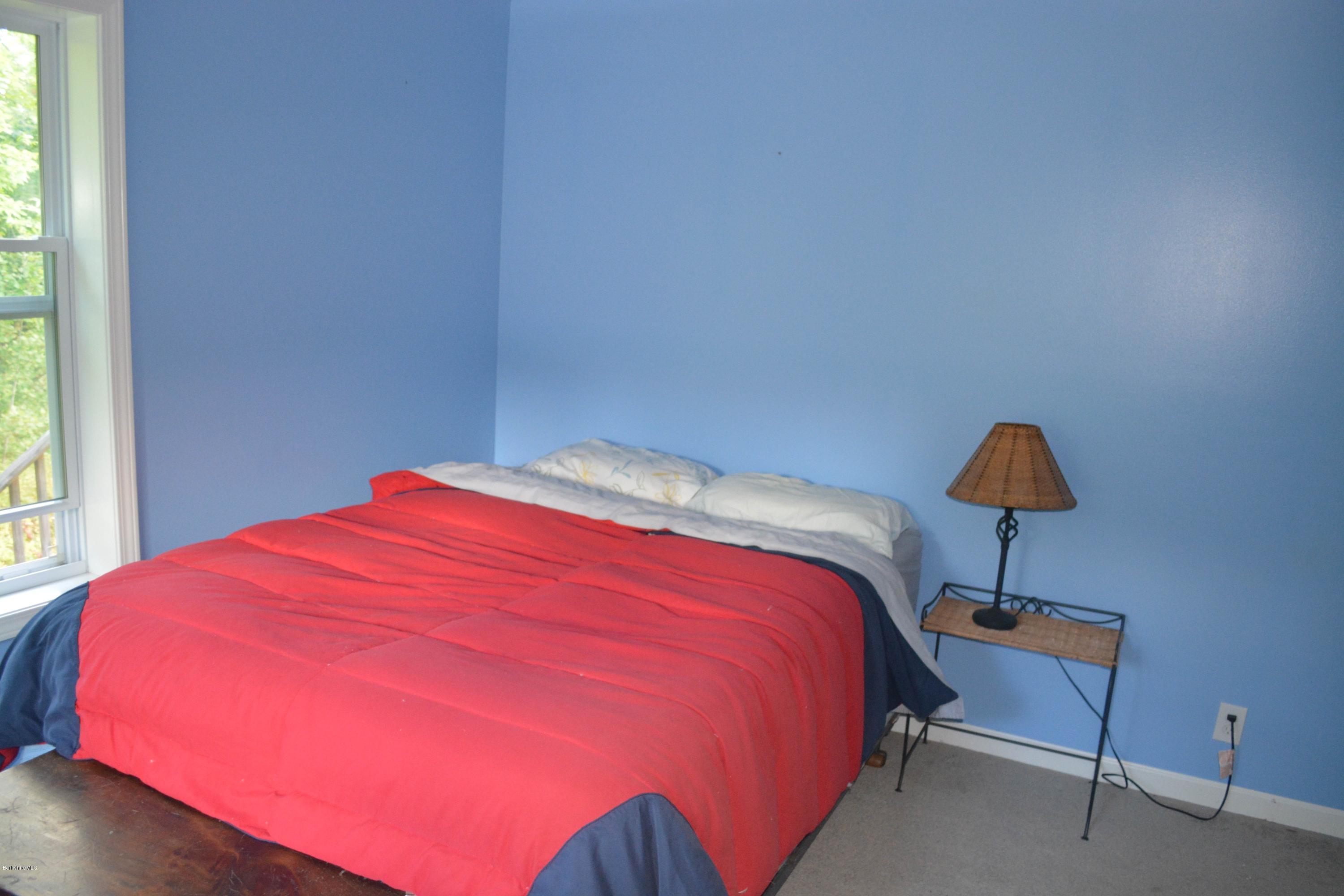 220 Sandisfield Road Sandisfield, MA 01255 - Photo 7 of 30 a bedroom with a bed and a lamp