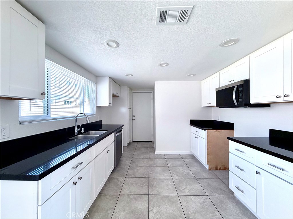 417 North Grove Avenue, Unit A Ontario, CA 91764 - Photo 5 of 17 a kitchen with stainless steel appliances a sink a stove a microwave a sink a counter top space and cabinets