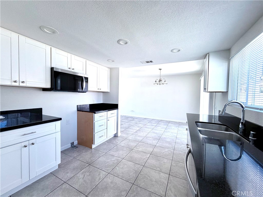 417 North Grove Avenue, Unit A Ontario, CA 91764 - Photo 6 of 17 a kitchen with a sink a stove and cabinets