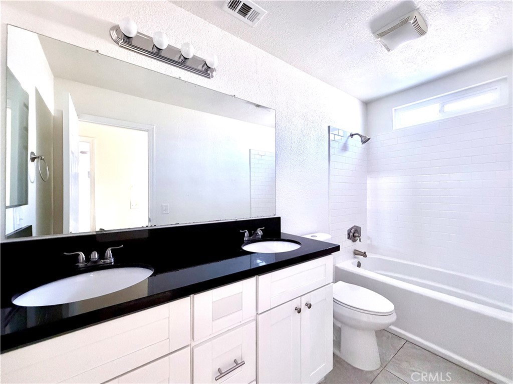 417 North Grove Avenue, Unit A Ontario, CA 91764 - Photo 8 of 17 a bathroom with a granite countertop sink and a mirror