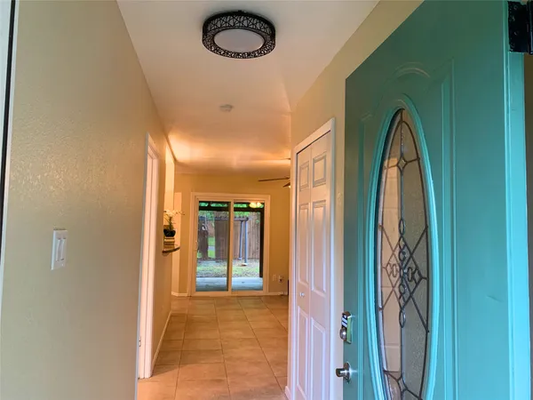 a view of a livingroom with a chandelier fan and windows