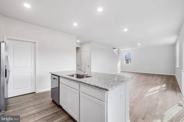 a kitchen with a sink granite counter tops and a wooden floors