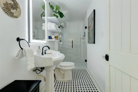 a bathroom with a sink toilet and a mirror