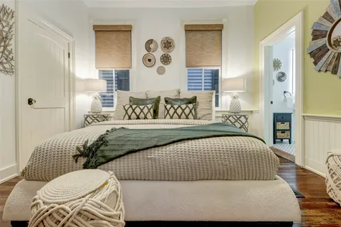 a bed sitting in a bedroom next to a lamp and a wooden table