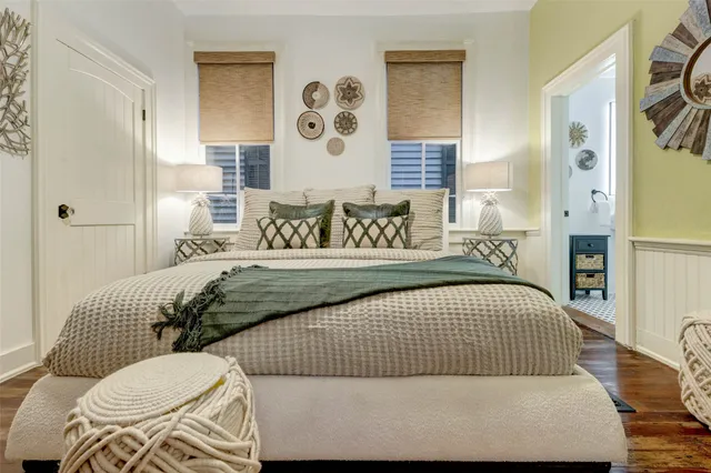 a bed sitting in a bedroom next to a lamp and a wooden table