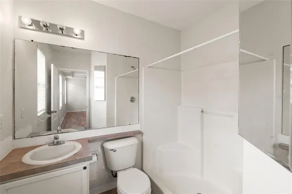 a bathroom with a toilet a sink and mirror