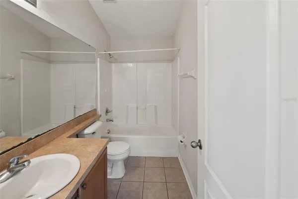 a bathroom with a granite countertop sink toilet a mirror and shower