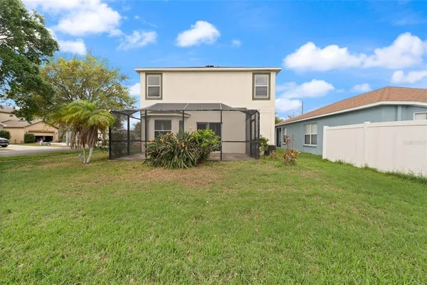 a front view of house with yard and trees in the background