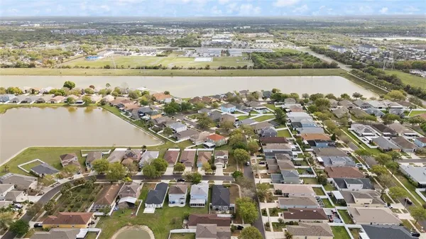 an aerial view of ocean and residential houses with outdoor space