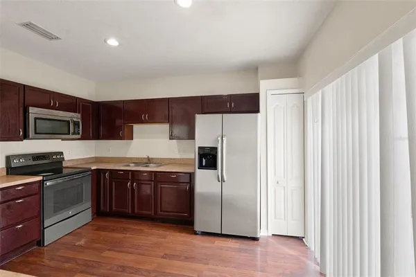 a kitchen with stainless steel appliances granite countertop a refrigerator and a stove top oven