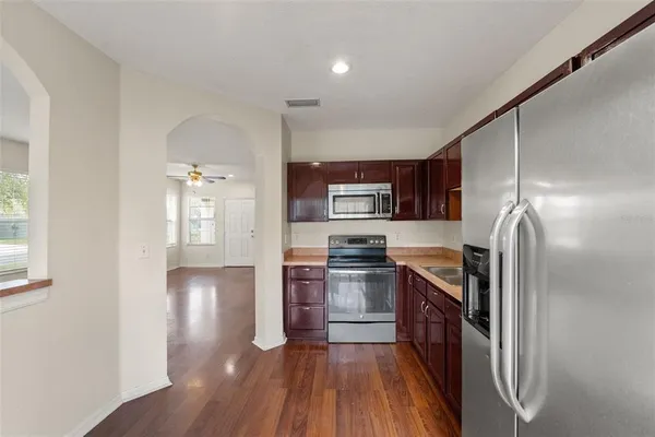 a kitchen with stainless steel appliances granite countertop a refrigerator and a stove top oven