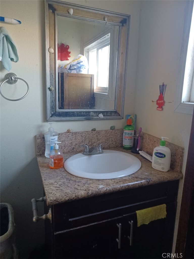 25508 Paloma Road Highland, CA 92410 - Photo 12 of 17 a bathroom with a granite countertop sink and a mirror