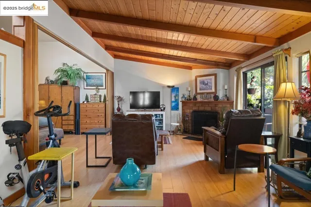 a living room with furniture a flat screen tv and a floor to ceiling window