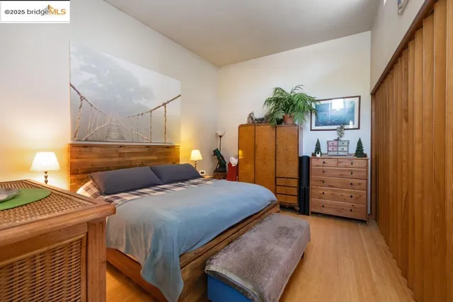 a bedroom with a bed a dresser and potted plants