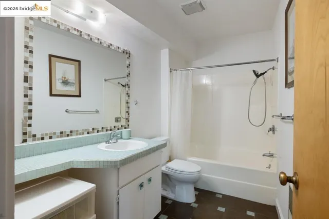 a en suite bathroom with a granite countertop sink and a mirror