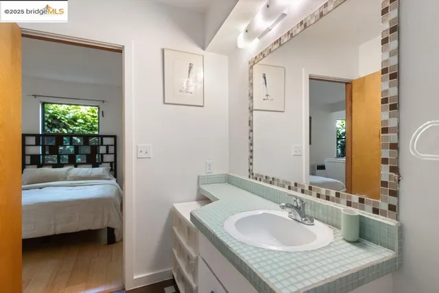 a living room with couches and a flat screen tv with kitchen view