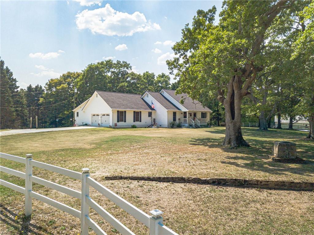 a view of walk in front of house with wooden fence