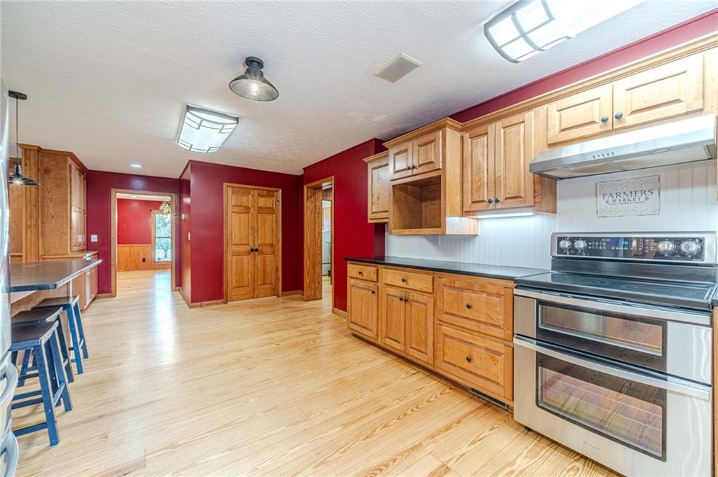 317 Duncan Road Oxford, GA 30054 - Photo 12 of 48 a kitchen with stainless steel appliances granite countertop a stove cabinets and wooden floor