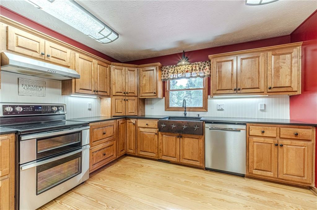 317 Duncan Road Oxford, GA 30054 - Photo 13 of 48 a kitchen with granite countertop wooden cabinets stainless steel appliances and a window