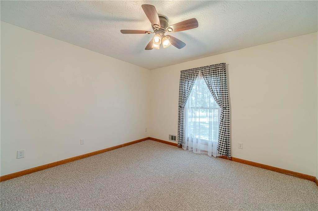 317 Duncan Road Oxford, GA 30054 - Photo 29 of 48 an empty room with a chandelier fan and windows
