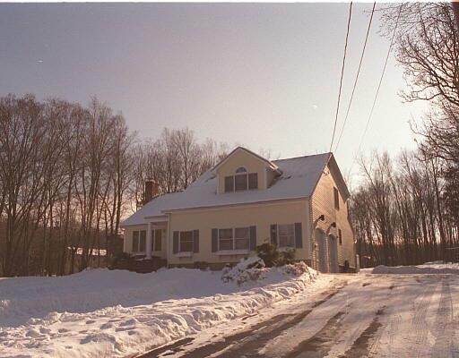 a front view of a house with a yard covered in snow