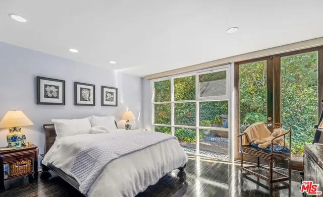 a bedroom with a bed and a large window