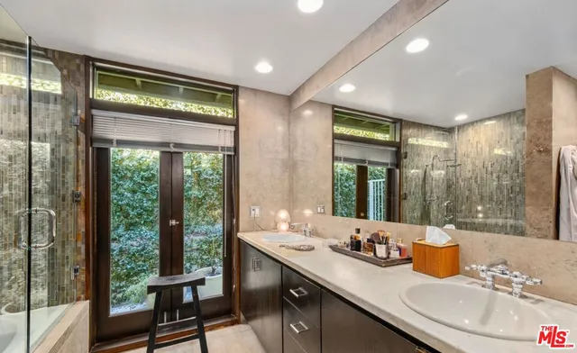 a bathroom with double vanity sinks and a mirror