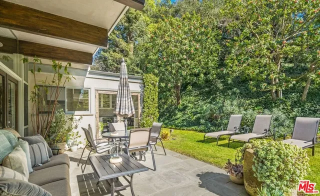 a view of a patio with table and chairs and potted plants