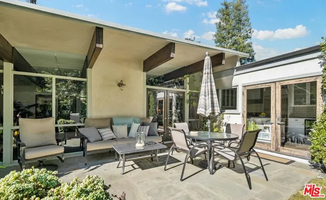 a view of a patio with table and chairs and potted plants