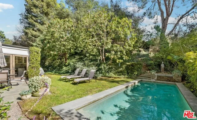 a view of a backyard with lawn chairs and a fire pit