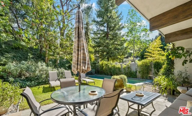 a backyard with a table and chairs and a large tree