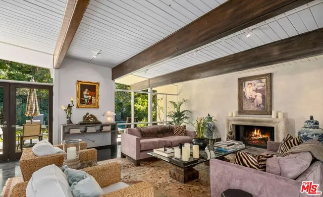 a living room with furniture a large window and a fireplace