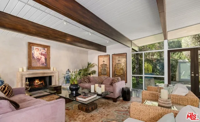 a living room with furniture fireplace and a large window