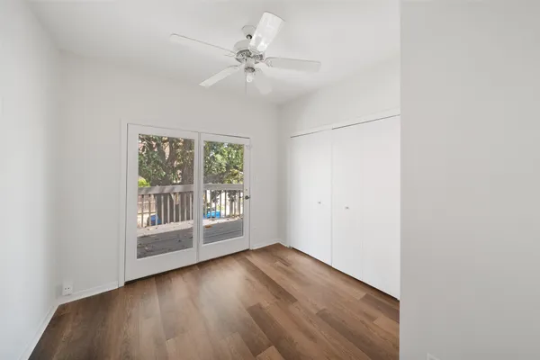 a view of a livingroom with wooden floor and a ceiling fan