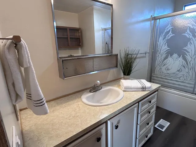 a bathroom with a granite countertop sink and a mirror
