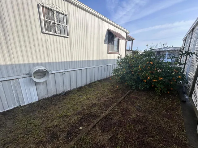 a view of a backyard with plants and brick wall