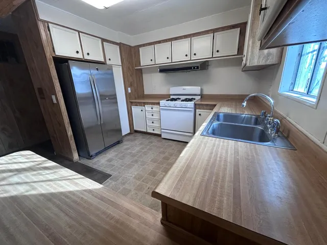 a kitchen with wooden floors and wooden cabinets