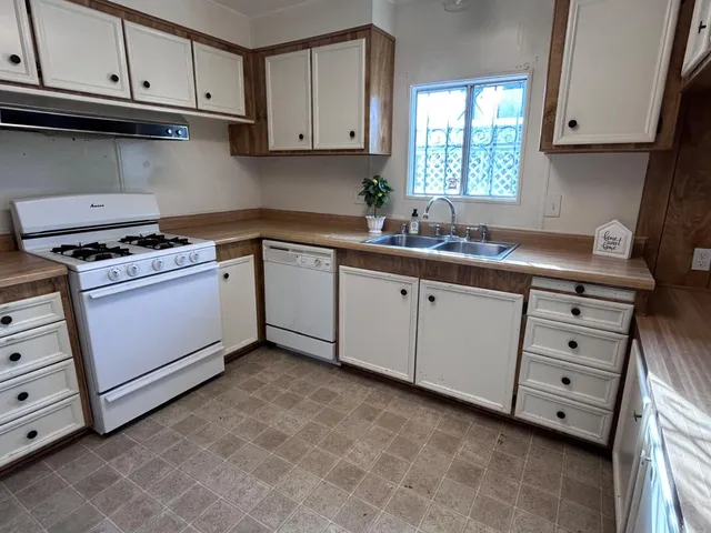a kitchen with cabinets appliances a sink and a window