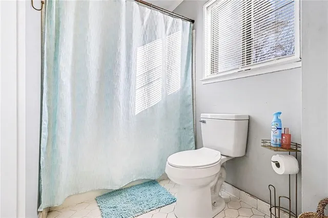 a bathroom with a toilet a sink and a window