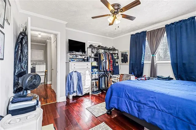 a bedroom with a bed and a flat tv screen on dresser