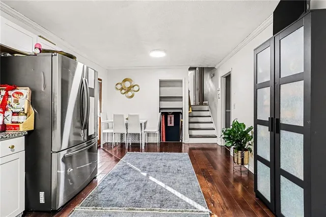 a kitchen with stainless steel appliances a refrigerator and wooden floor