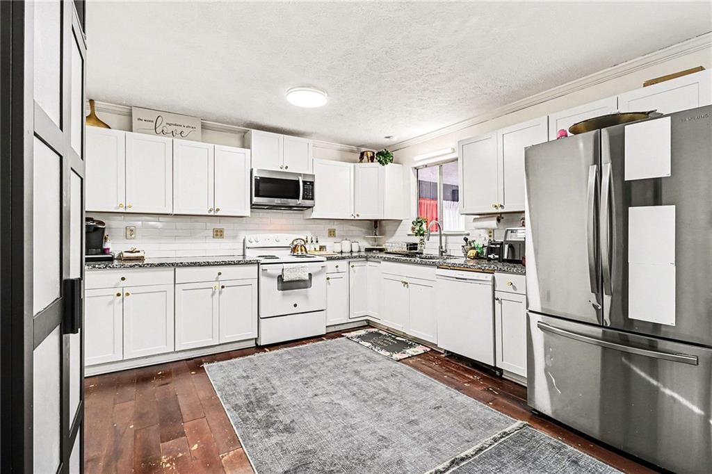 6186 Deans Way Morrow, GA 30260 - Photo 10 of 35 a kitchen with granite countertop a refrigerator stove top oven and sink
