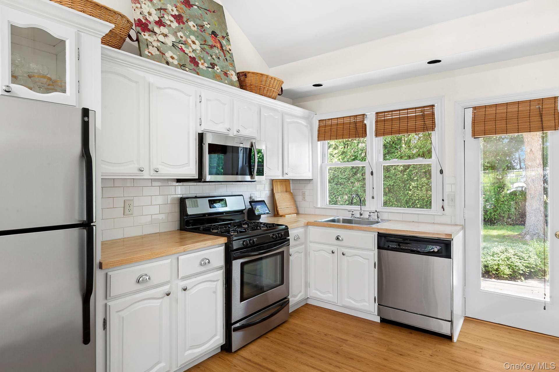 315 Old Salt Road Mattituck, NY 11952 - Photo 11 of 22 a kitchen with white cabinets and appliances