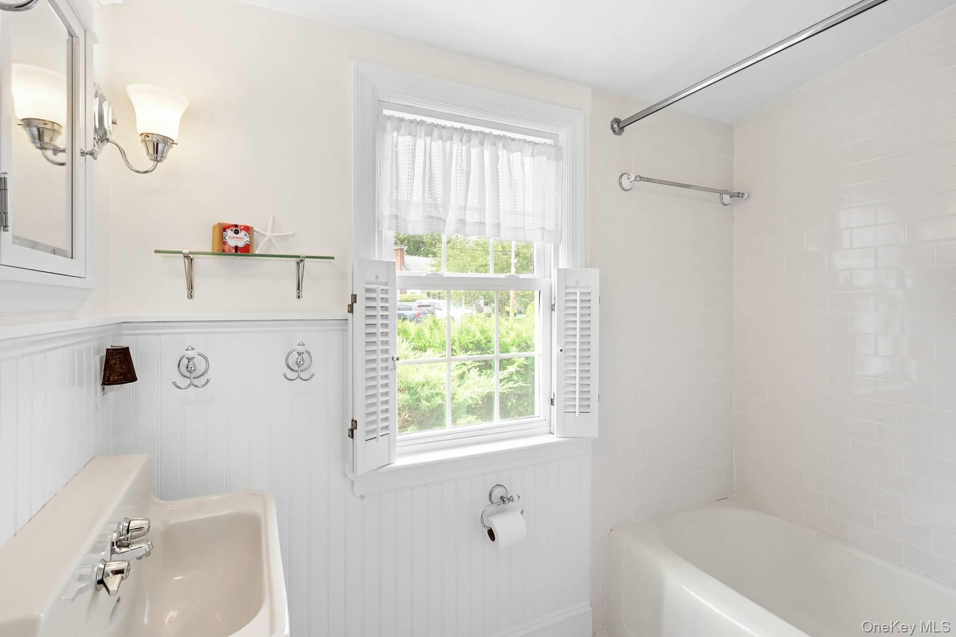 315 Old Salt Road Mattituck, NY 11952 - Photo 17 of 22 a bathroom with a bathtub a sink and a window