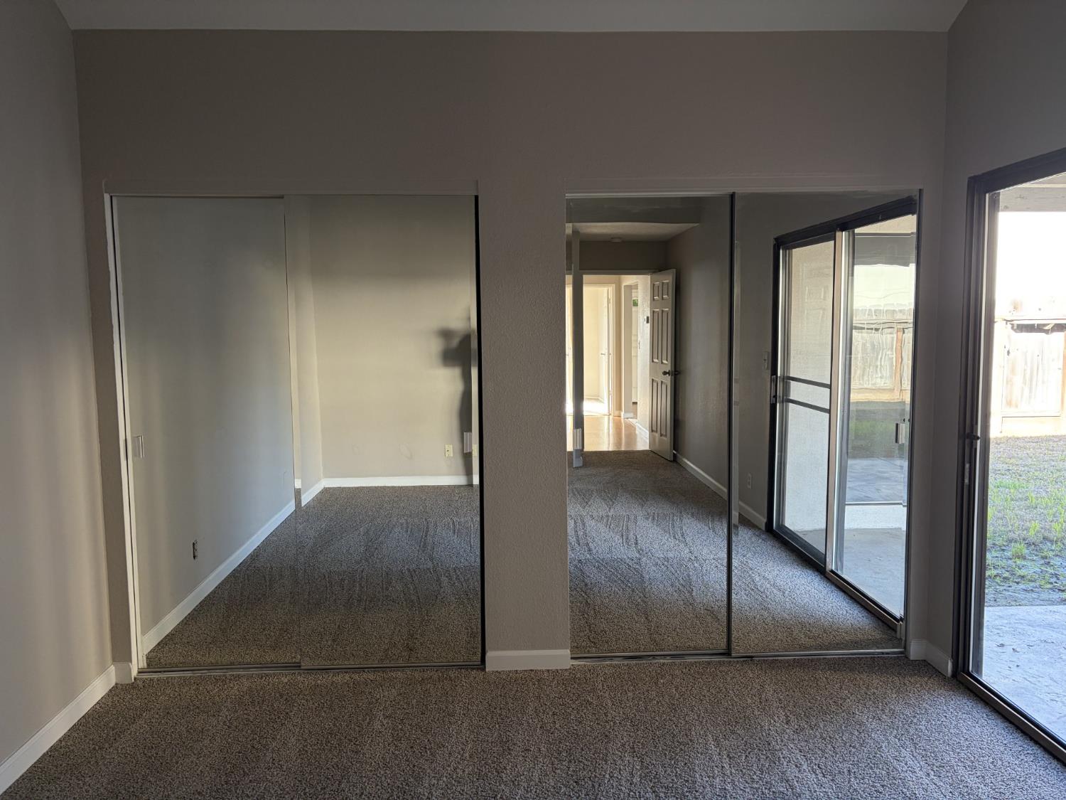 2401 Walnut Grove Way Modesto, CA 95355 - Photo 13 of 25 an empty room with wooden floor and windows