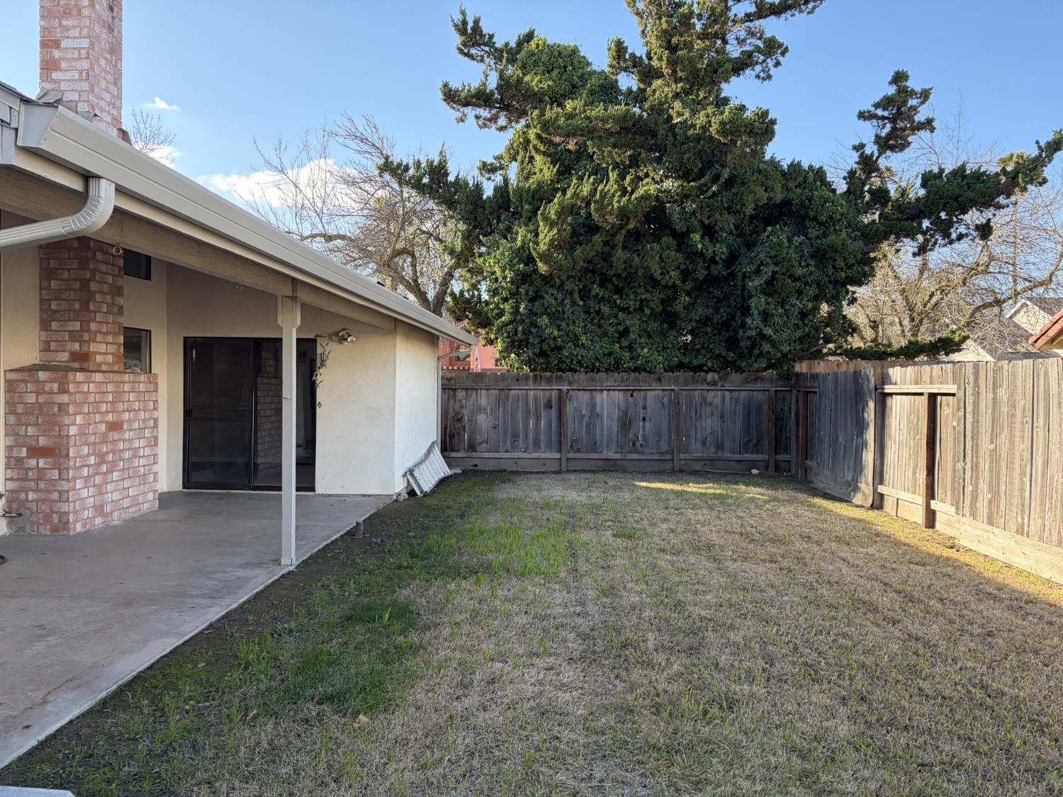 2401 Walnut Grove Way Modesto, CA 95355 - Photo 19 of 25 a view of a backyard with large trees and wooden fence